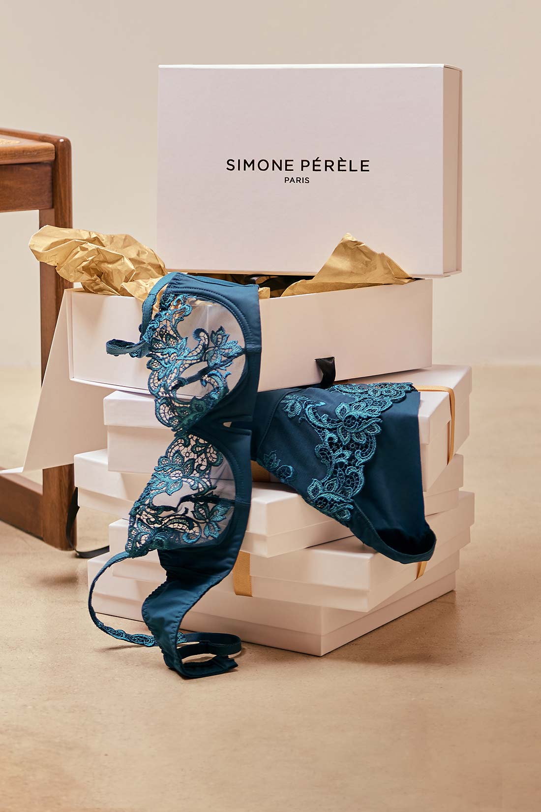 Blue lace bra draped over a white box with 'Simone Perele' branding.